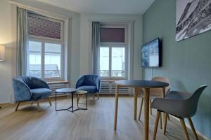 a room with chairs and a table and two windows at BANK House Studio L 205 - GRIWA RENT in Interlaken