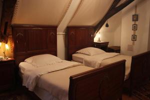 1 Schlafzimmer mit 2 Betten mit Kopfteilen aus Holz in der Unterkunft Chateau-Gaillard in Corbelin
