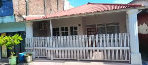 a small house with a white picket fence at Soraya Homestay Malang in Rampal