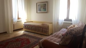 - un salon avec un canapé et 2 fenêtres dans l'établissement Chiara Apartment, à Mestre