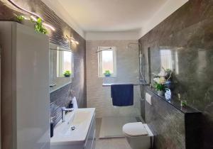 a bathroom with a sink and a toilet and a tub at APARTMENT ELI in Pag +61 photos