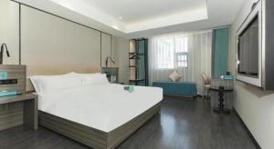 a bedroom with a large white bed and a television at Xana Lite Xichang Hangtian Avenue Branch in Xichang +17 photos