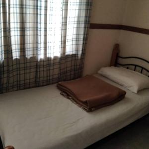 a bed in a room with a window at Genting Bukit tinggi meranti park in Bentong