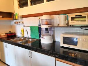 a kitchen counter with a sink and a microwave at Genting Bukit tinggi meranti park in Bentong +4 photos