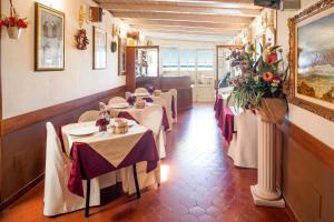 a row of tables in a restaurant with flowers on the wall at Hotel Tina in Diano Marina