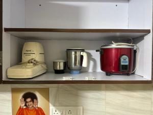 a shelf with various appliances on it in a kitchen at Brownie Paradise in Puttaparthi +7 photos