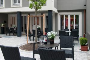 a patio with chairs and a table with a tree at Hotel im Hof in Munich