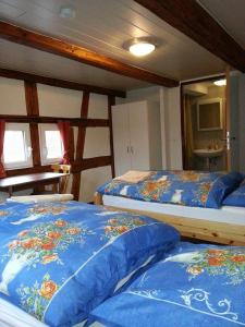 ロットヴァイルにあるGasthaus Rössleのベッドルーム1室(青い掛け布団付きのベッド2台付)