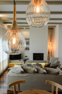 two large glass pendant lights hanging over a couch at Gatzea Villas in Kato Gatzea