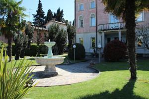 a fountain in front of a house with a building at Park Hotel Villa Leon d'Oro in Noventa di Piave