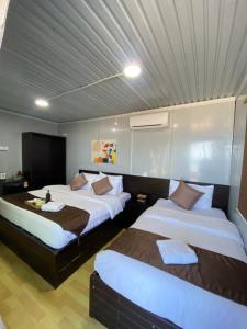 two beds in a hotel room with two bedsskirts at Cenanghill Beachfront in Pantai Cenang