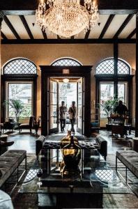 a lobby with a chandelier and people standing in the doorway at Hotel Normandie Los Angeles in Los Angeles