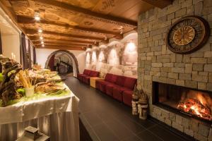 a living room with a fireplace and red couches at Hotel Rezia in La Villa