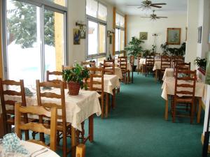 a dining room with tables and chairs in a restaurant at Hôtel Le Grand-Bec in Pralognan-la-Vanoise