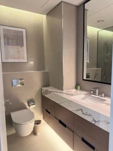 a bathroom with a toilet and a sink and a mirror at Address Beach Resort Fujairah Apartment by Blue World - 2 in Fujairah