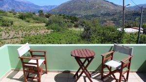 two chairs and a table on a balcony with mountains at Elia Meronas in Méronas