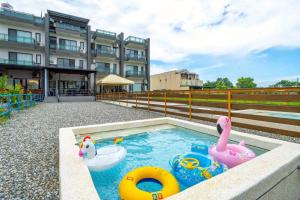 宜蘭市にある117 Vacation homeの建物の前にある2つの膨らませるおもちゃのあるプール