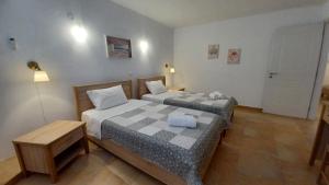 a bedroom with two beds and a table and a door at Blue Xenia - Villa 4 in Chrissi Akti +37 photos