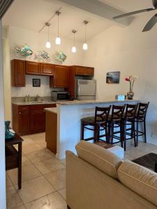 a kitchen with a couch and a bar with chairs at Kauai Getaway Condo in Kapaa