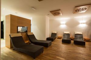 a waiting room with chairs and a flat screen tv at Hotel Rezia in La Villa