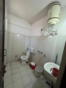 a small bathroom with a toilet and a sink at Celebrate Vacation New Shanti Palace in Badrīnāth +7 photos