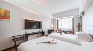 Una habitación de hotel con dos camas y un televisor de pantalla plana. en Zhuhai Aqueen Hotel, en Zhuhai 178 fotos más
