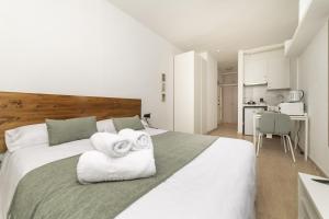 a bedroom with a white bed with towels on it at Classy VII - Ferga Suites in Madrid