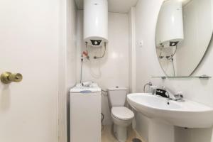a bathroom with a toilet and a sink and a mirror at Classy VII - Ferga Suites in Madrid