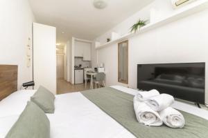 a bedroom with a white bed with towels on it at Classy VII - Ferga Suites in Madrid