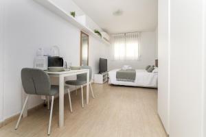 a white room with a desk and a bed at Classy VII - Ferga Suites in Madrid
