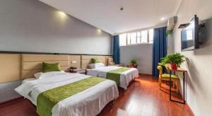 a hotel room with two beds and a tv at GreenTree Inn Yancheng Dongtai West Wanghai Road Shell Hotel in Dongtai +166 photos