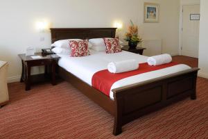a bedroom with a large bed with red and white pillows at Park Central Hotel in Bournemouth