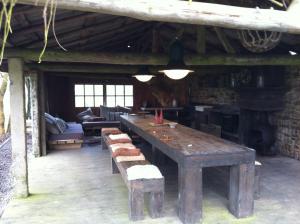 einen großen Holztisch in einem Zimmer mit Kamin in der Unterkunft Le Menil in Manhay