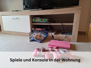 a table with a tv and a pink toy gun at FeWo Berg-Domizil Bad Harzburg mit eigenem Fahrradkeller und Parkplatz, inklusive Bettwäsche und Handtüchern in Bad Harzburg