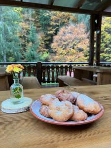 a plate of donuts on a table with a vase at Transfagarasan Moto&Cabin Camp in Văleni +56 photos