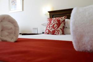 a bedroom with a bed with a red and white pillow at Park Central Hotel in Bournemouth