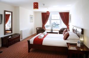 a bedroom with a bed and a desk and a window at Park Central Hotel in Bournemouth