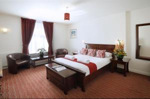 a hotel room with a bed and two chairs at Park Central Hotel in Bournemouth