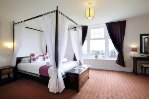 a bedroom with a canopy bed and a window at Park Central Hotel in Bournemouth
