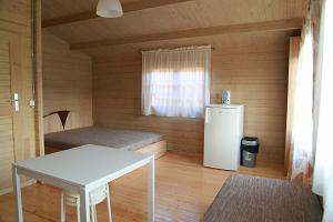 a room with a refrigerator and a table in a cabin at Nemirsetos Nameliai in Palanga
