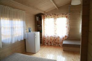 a room with a small refrigerator and a window at Nemirsetos Nameliai in Palanga