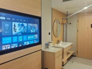 a bathroom with a large screen television and a sink at GreenTree Inn Shanghai Songjiang WanDa Plaza RonGMEi Road Express Hotel in Shanghai +209 photos
