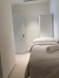 a white bedroom with a bed and a door at Address Beach Resort Fujairah Apartment by Blue World - 3 in Fujairah +14 photos