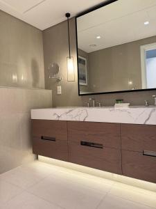 a bathroom with a large sink and a large mirror at Address Beach Resort Fujairah Apartment by Blue World - 3 in Fujairah