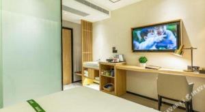 Habitación con escritorio y TV en la pared. en GreenTree Inn Shandong Jinan Suncun New District Express Hotel, en Jinan 77 fotos más