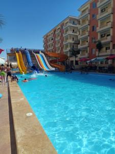 a large swimming pool with a water slide at شاليه بالساحل الشمالى قرية نيو كوست الكيلو 77 قبلى الطريق بشاطىء خاص in El Alamein