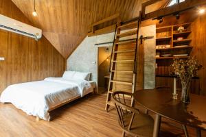 a bedroom with a bed and a table and a ladder at Issara Bar&House in Ko Larn