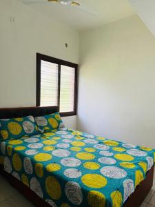 une chambre avec un lit avec une couette colorée dans l'établissement Golden Heights Apartments, à Trivandrum