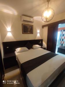 a bedroom with a large bed and a chandelier at Porto Marina North Cost, Coastal Panorama in El Alamein