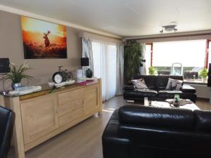 a living room with a couch and a table at Veluwe Park Reewold Chalet Talisman in Putten